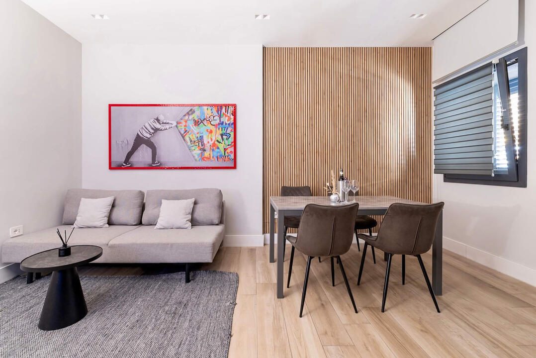 Bright and welcoming living area with comfortable seating, large TV, and cozy atmosphere.